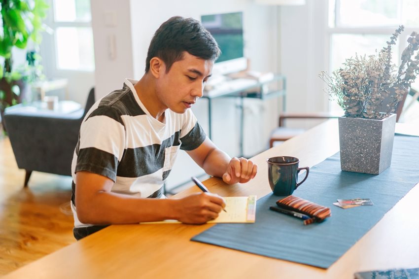 man-writing-on-notepad-inside-house-1386612.jpg